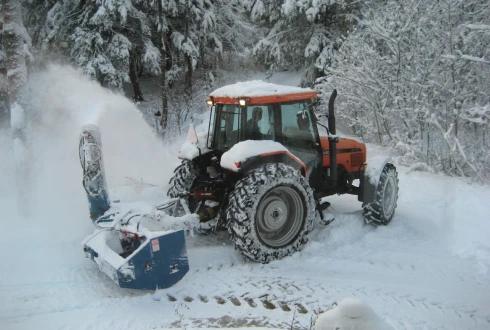 Un tracteur qui souffle de la neige.