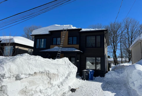 Une maison qui est en train de se faire déneiger la toiture par l’équpe d’À Point déneigement.