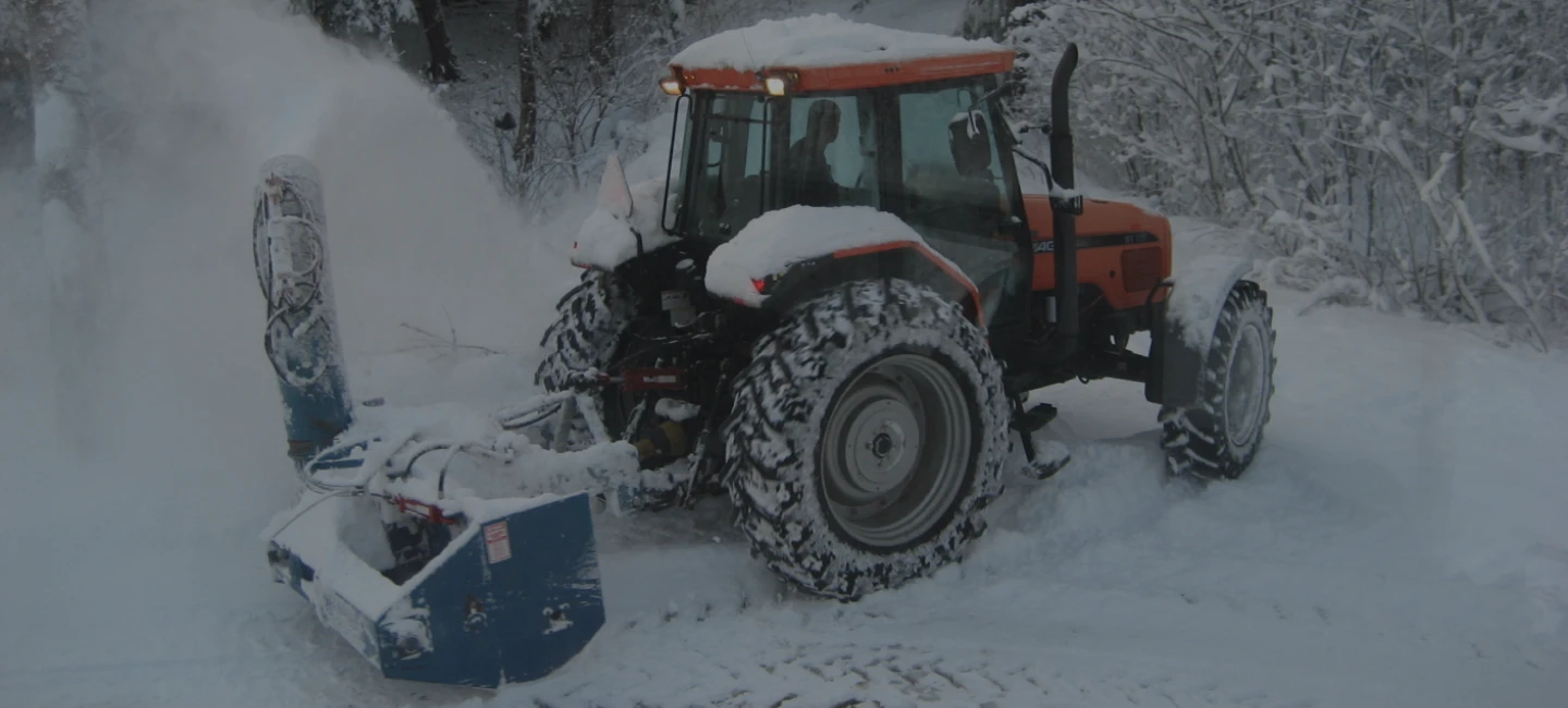 Un tracteur qui souffle de la neige.